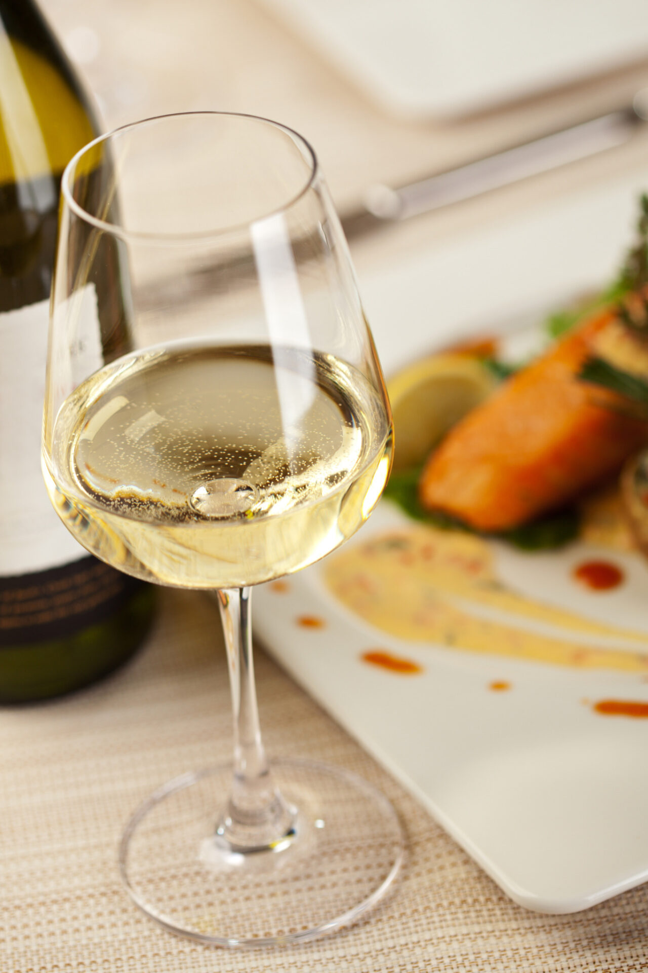 Fumé Blanc in a white wine glass next to a plate of salmon