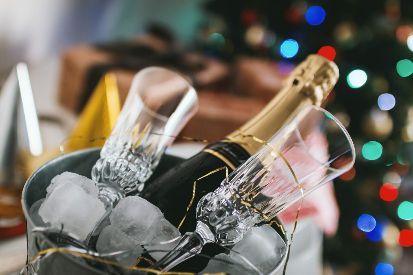 A bottle of champagne and two flute glasses sitting in an ice bucket