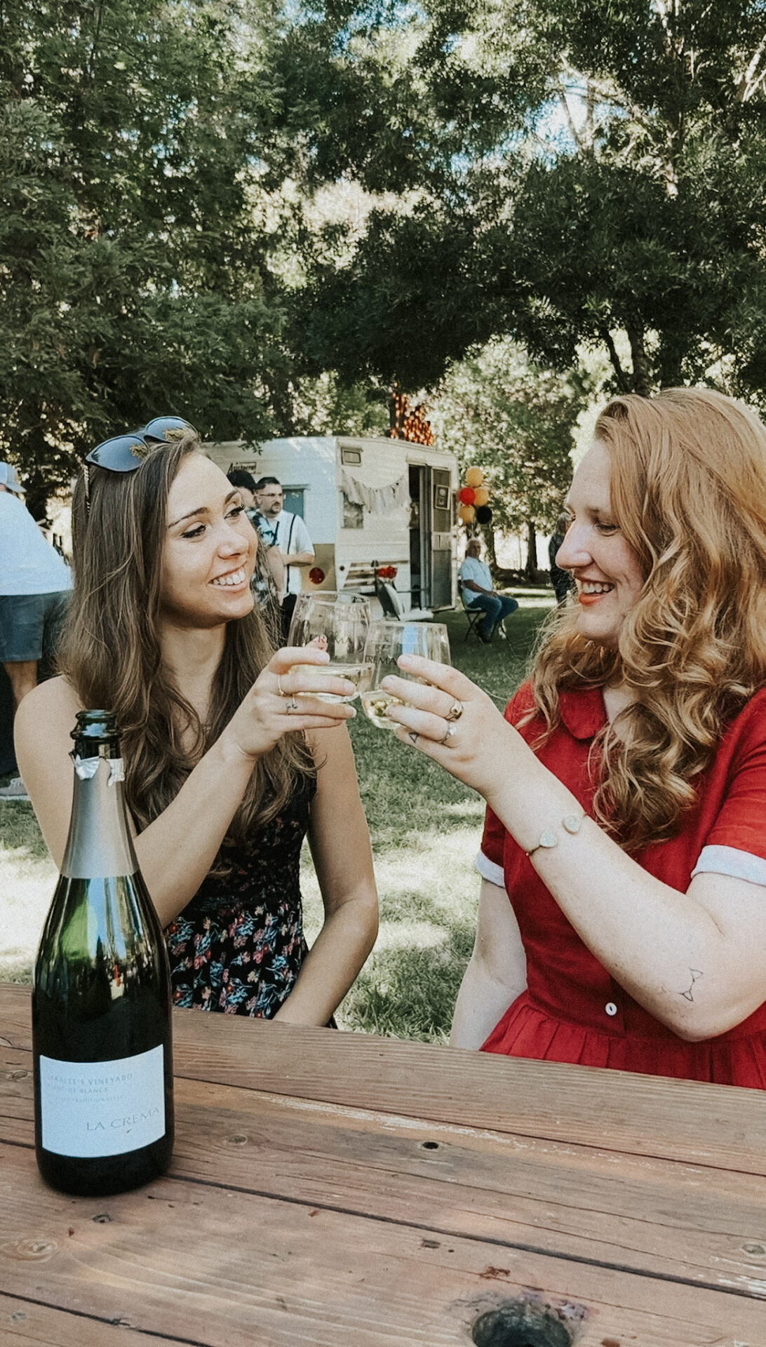 Two women cheersings with a bottle of La Crema at Bottles & Broadway