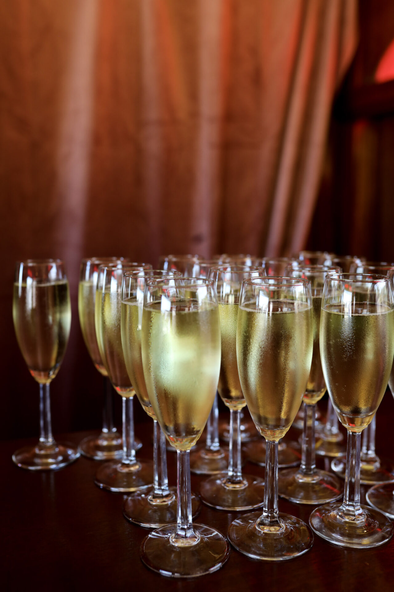 Many glasses of open champagne flutes on a table