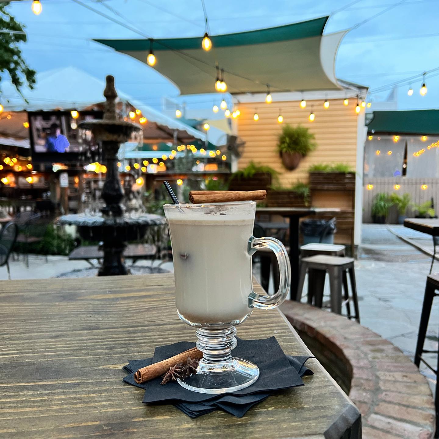 A mixed drink sits atop a table on an outdoor patio