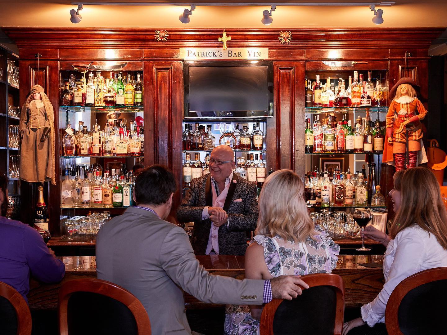 Patrick of Patrick's Bar Vin serves customers from behind the bar