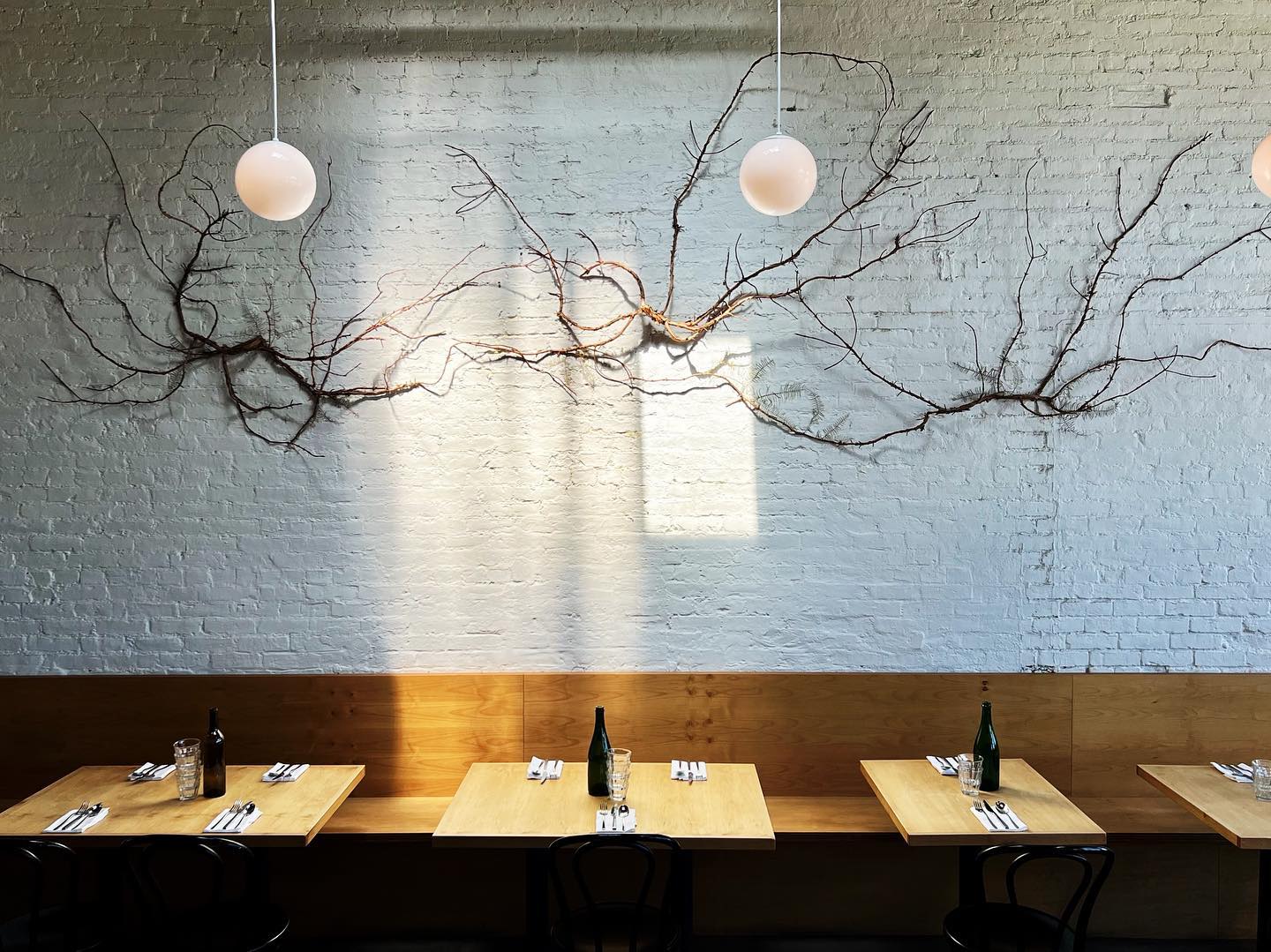Rustic brick restaurant interior with modern lighting and hanging dried branches