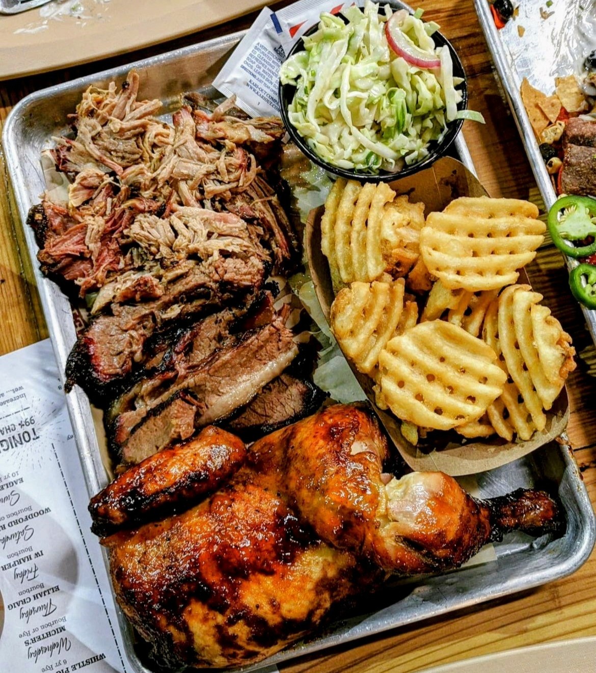 Barbecue items photographed next to sides of waffle fries and Cole slaw