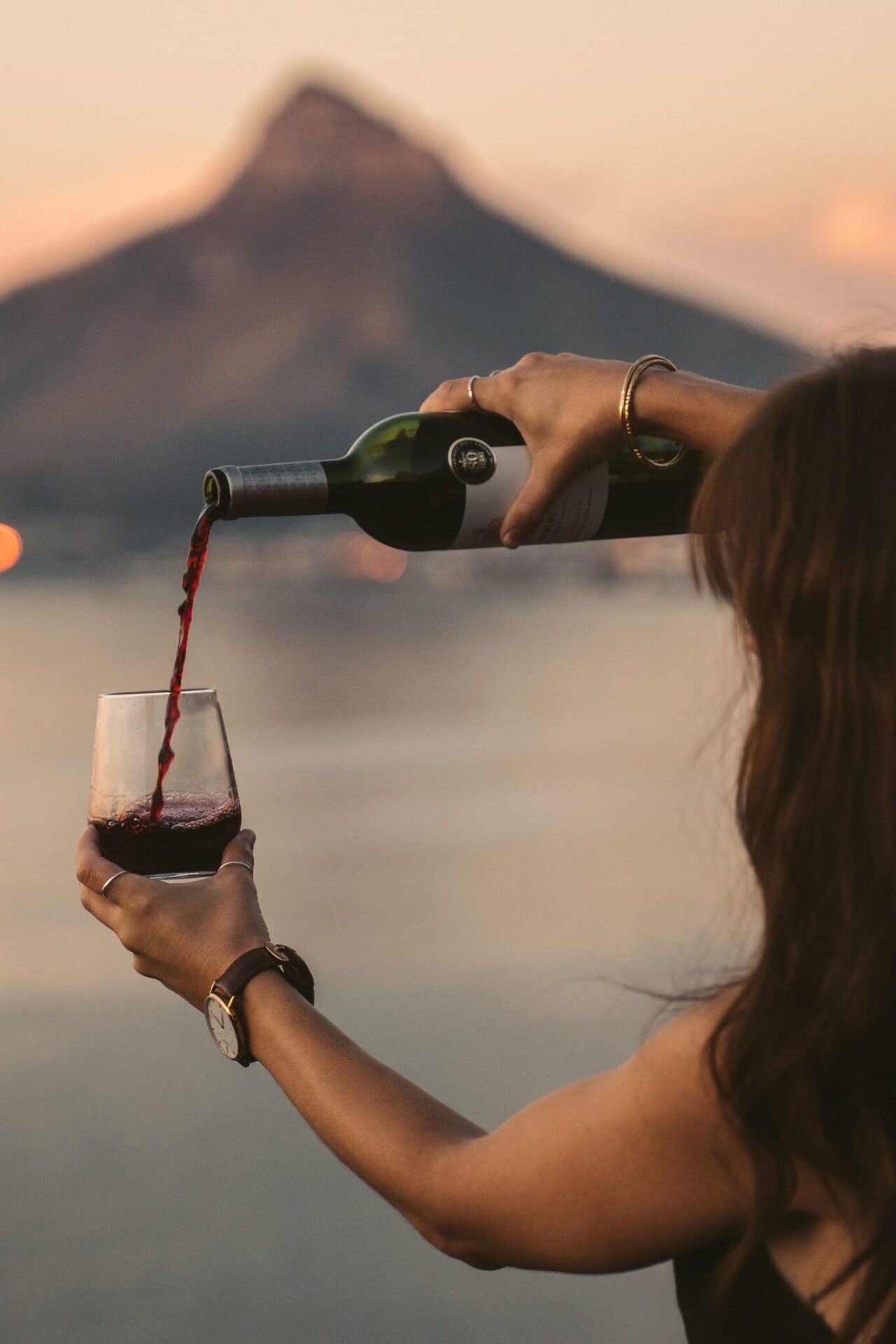 Woman pouring wine with mountain in distance