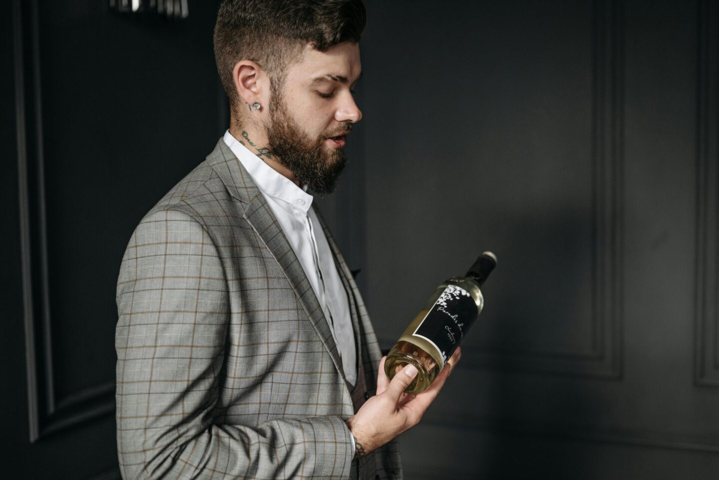 A man in gray suit holding wine glass