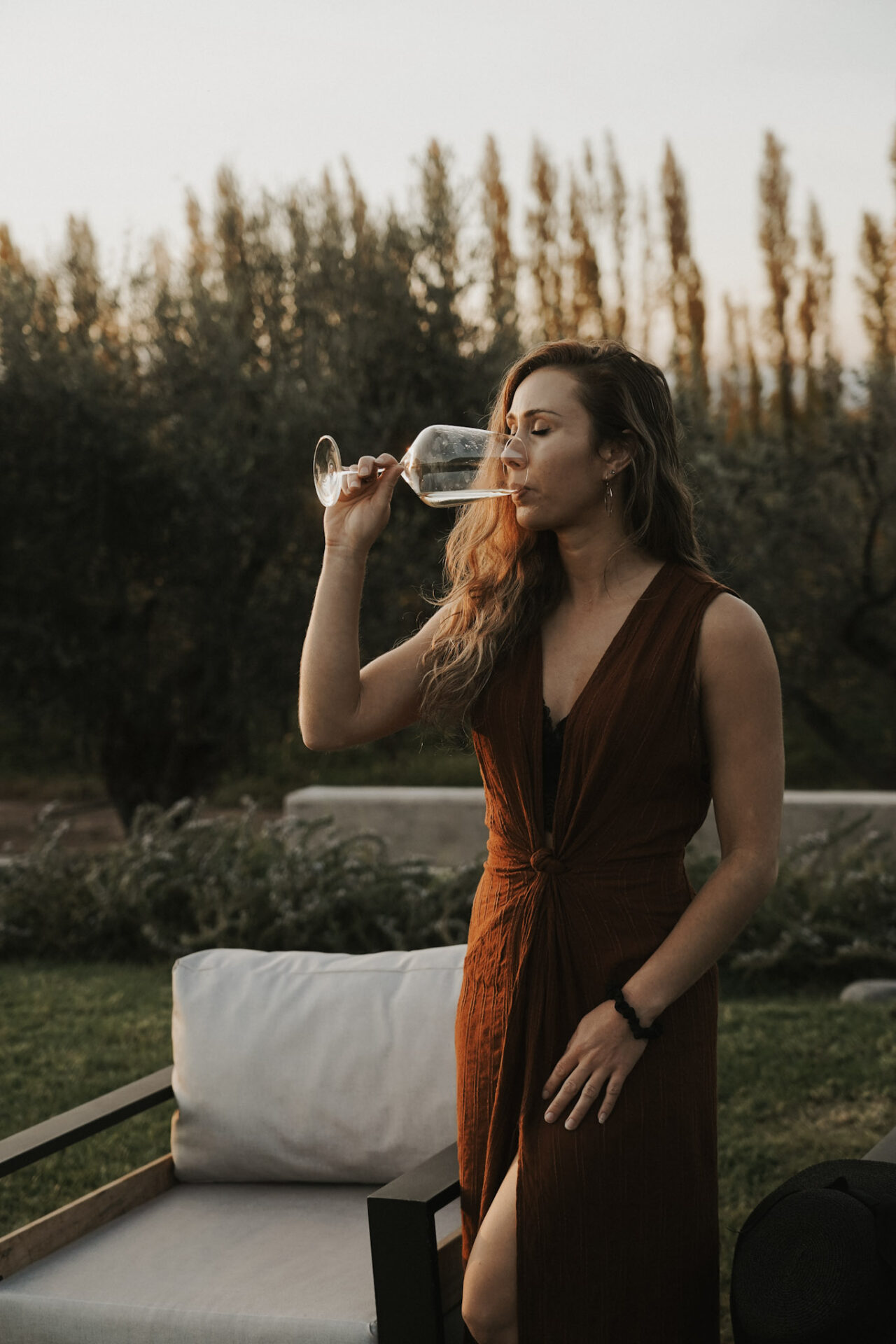 Paige enjoying a glass of wine outdoors at golden hour