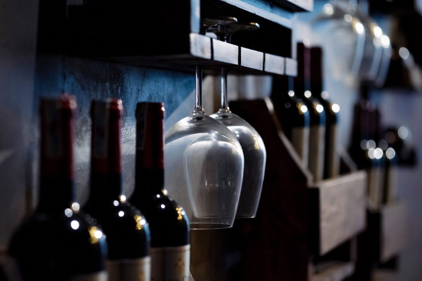 wine glasses hanging and wine bottles